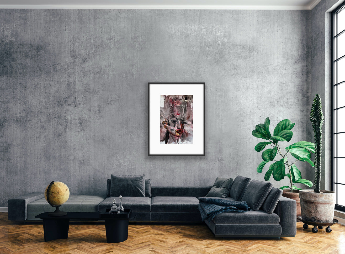 Modern living room with a gray sofa, decorative plant, and framed artwork on a gray wall.