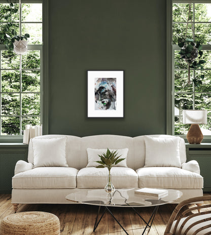 Living room with a white sofa, coffee table, and framed picture on a green wall.