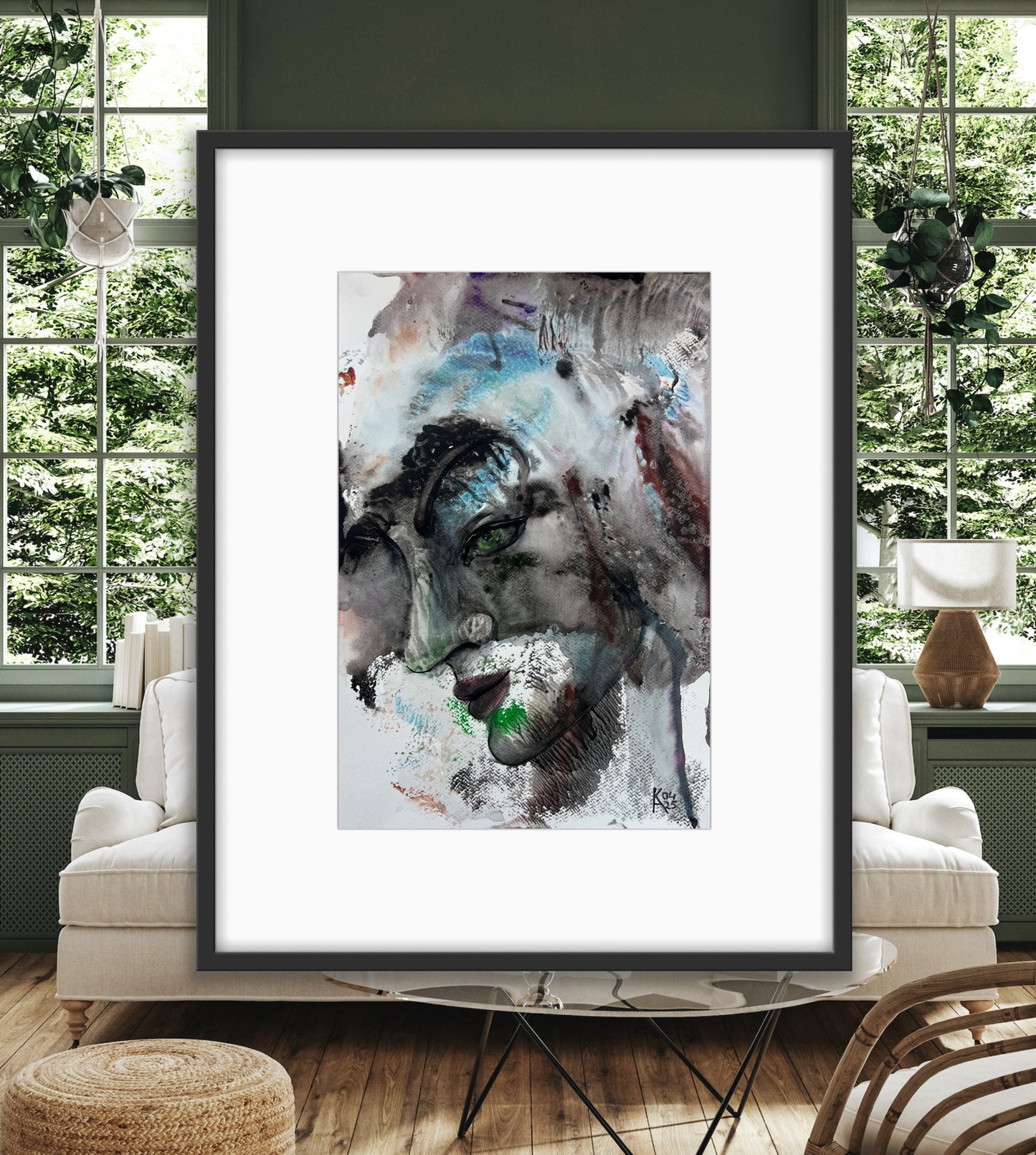 Framed abstract art piece in a modern living room setting with large windows.
