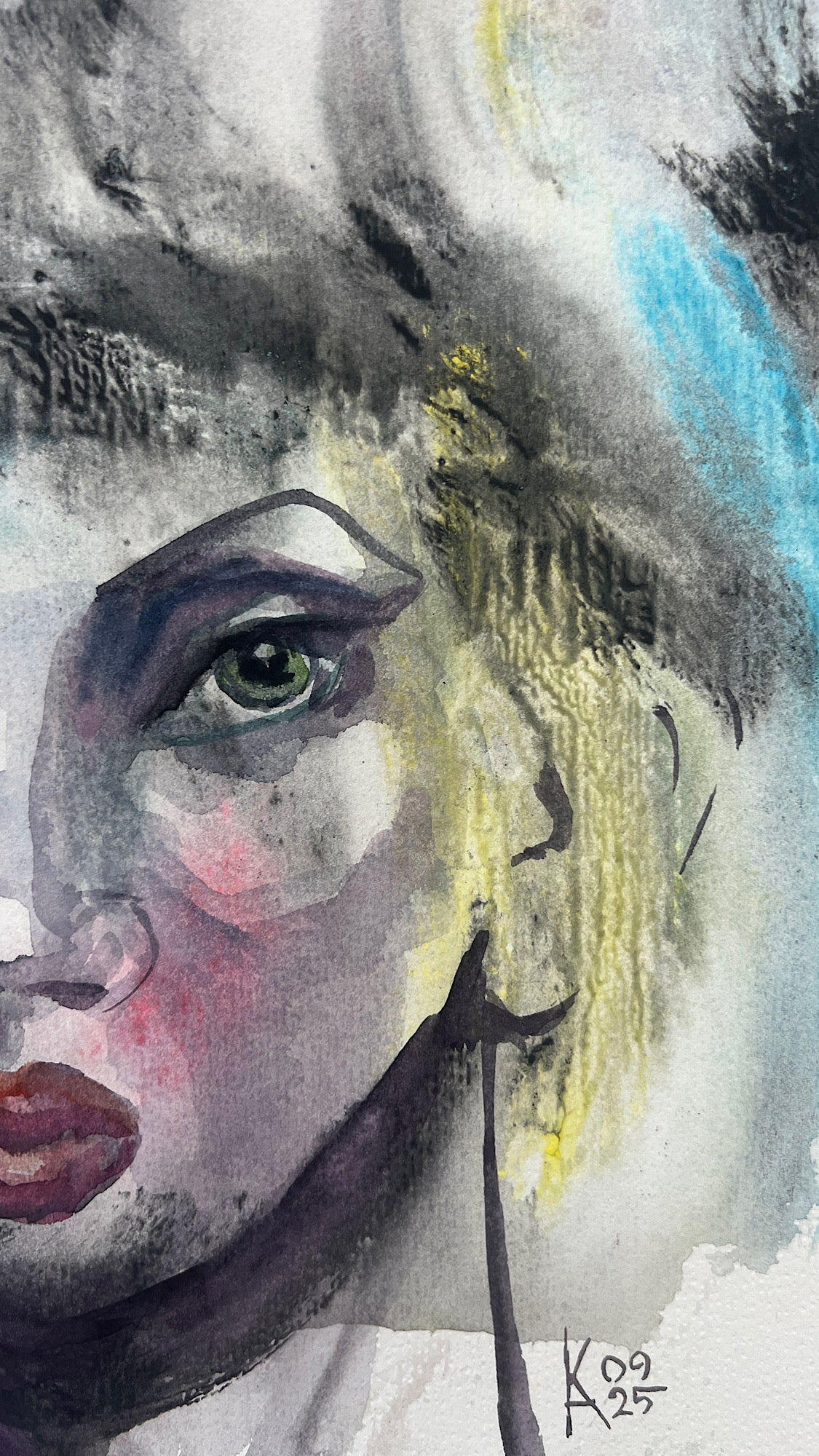 Close-up of an abstract watercolor face showing vivid green eyes, red lips, and the artist's signature.