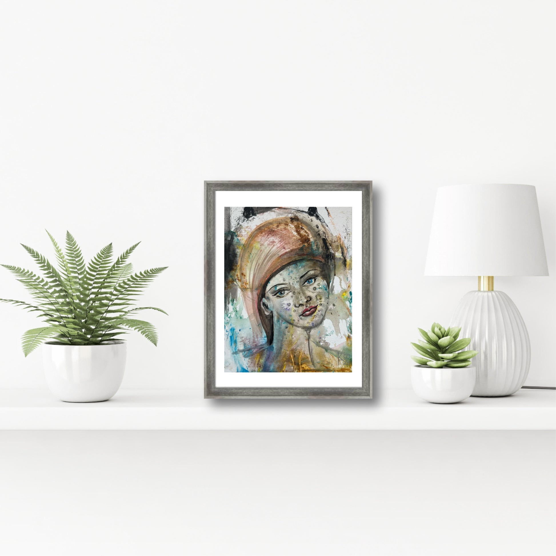 Original acrylic portrait painting in gray frame on shelf with fern plant and white lamp, surrealist feminine art by Ekaterina Anchugova